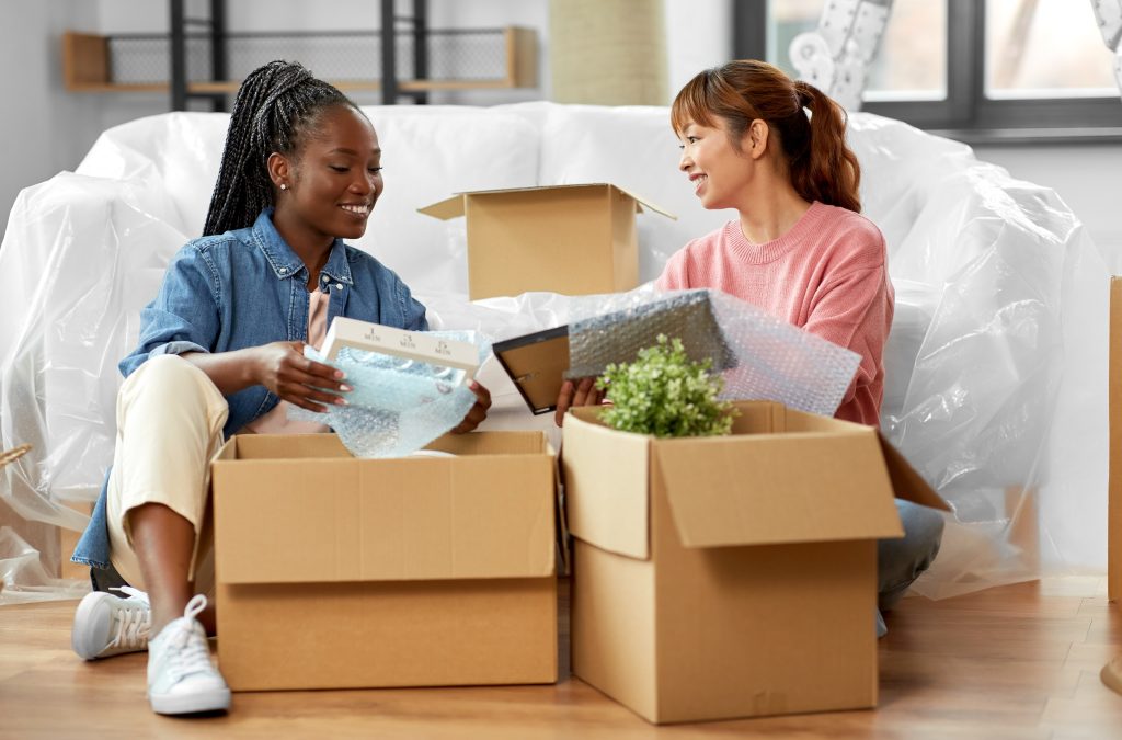 women unpacking boxes and moving to new home
